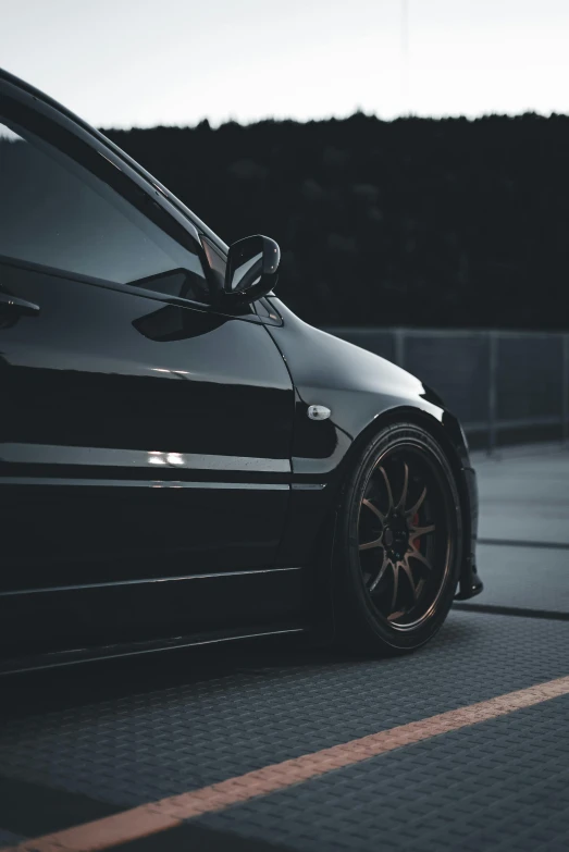 a black sports car parked in a parking lot with its door open