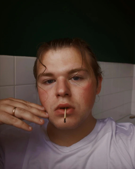 a woman in white shirt eating soing with a ring on it's finger