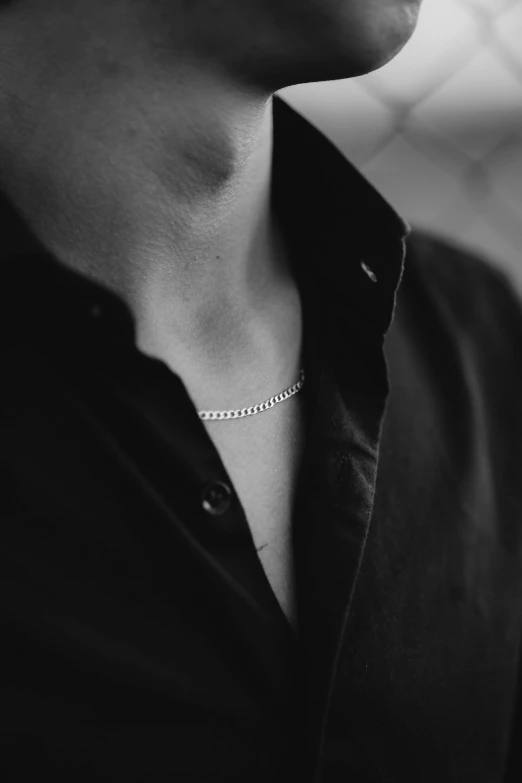 a young man wearing a collared shirt and looking straight ahead