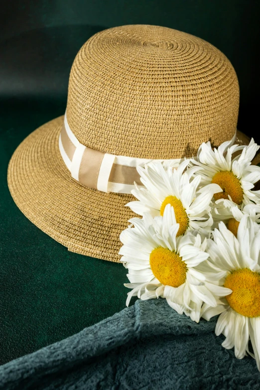 a hat and two flowers sit atop a blanket