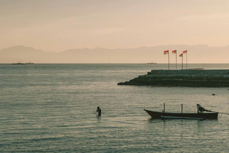 two boats in the ocean at sunset with a sky background