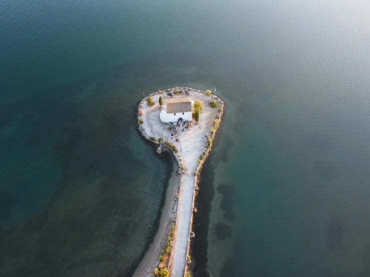 an island with a lighthouse, water, and buildings in it