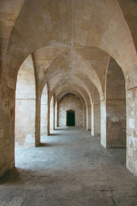 a long hallway with arches and cobblestones