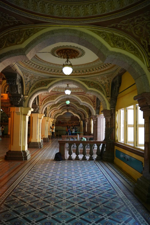 the interior of an old building with pillars and tile flooring