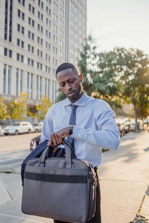 an african man holding a briefcase on the street