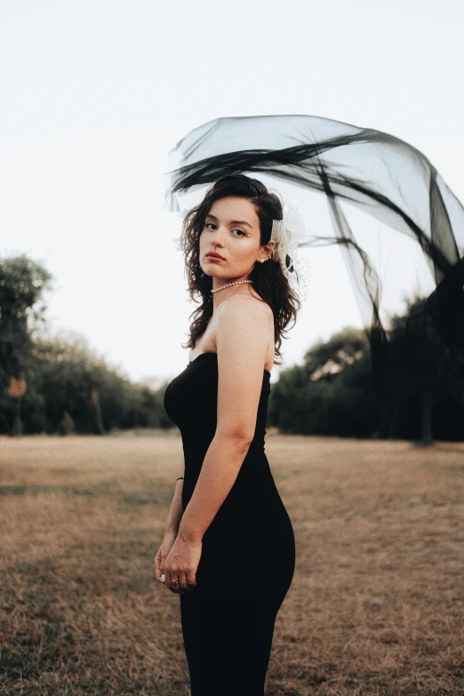 a woman poses outside holding an umbrella