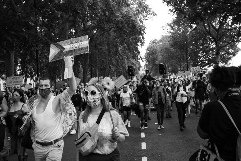 people walking down the street while holding up signs