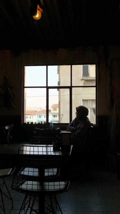 a person sitting at a table with a laptop