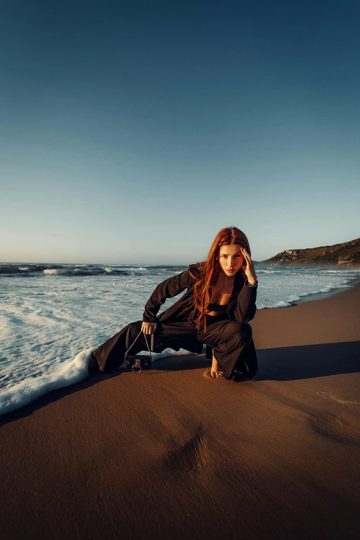 a  sitting on a beach next to the ocean