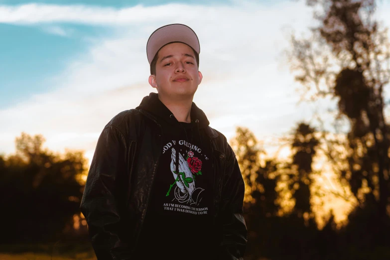 a young man smiling with trees in the background