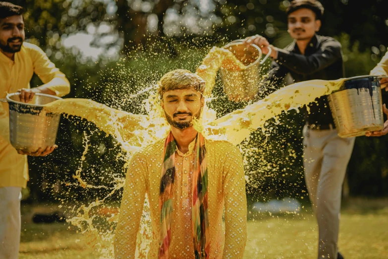 a group of men are tossing water over their heads