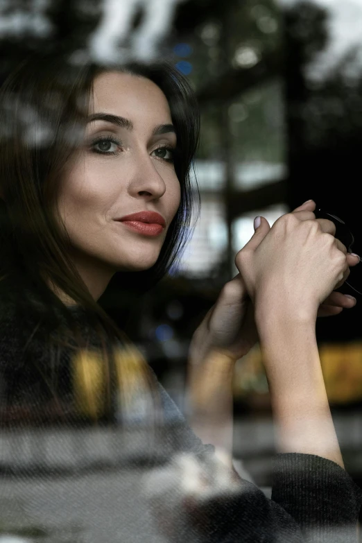 a woman with a smile on her face and her hands folded