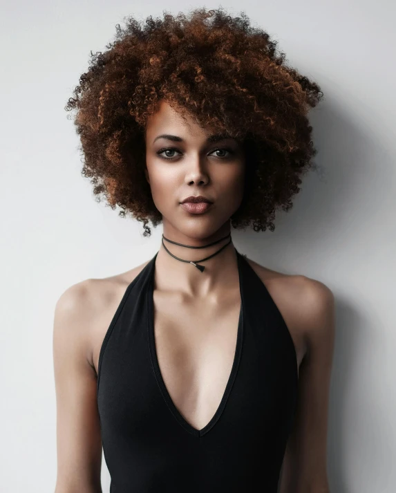 a woman with an afro wearing a halter top