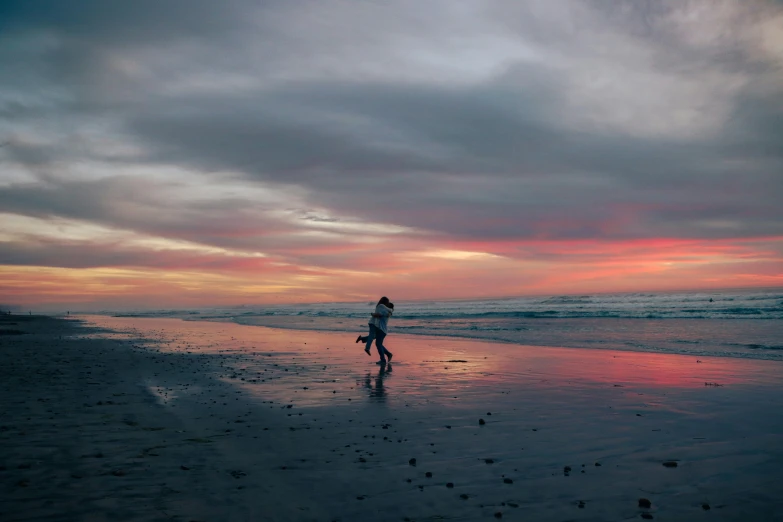 a person walking along a beach next to the ocean