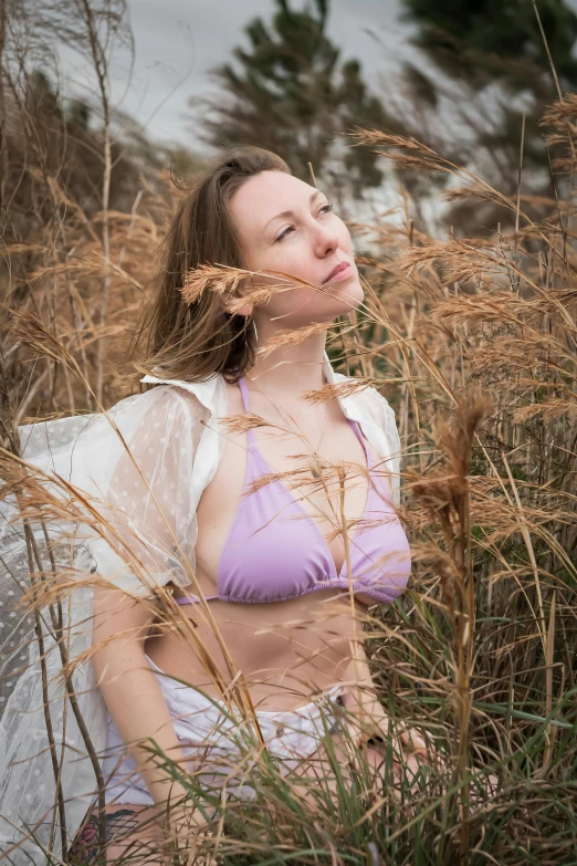 a woman wearing a  sits in tall grass