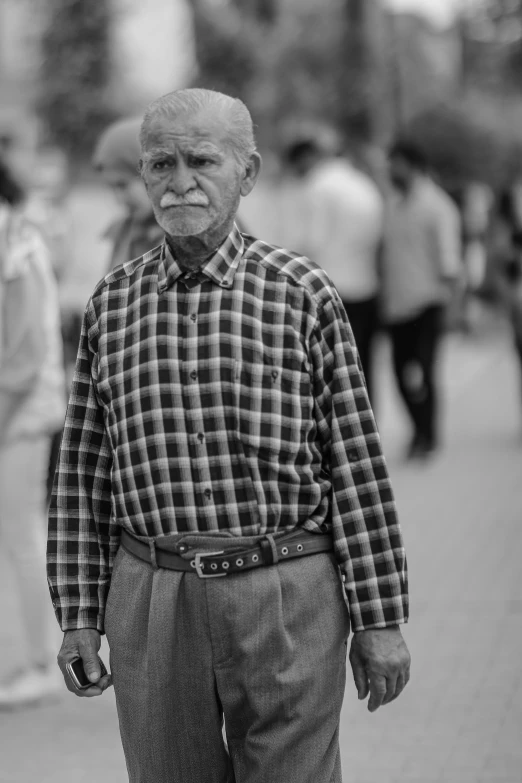 an old man with a sad look standing on the street