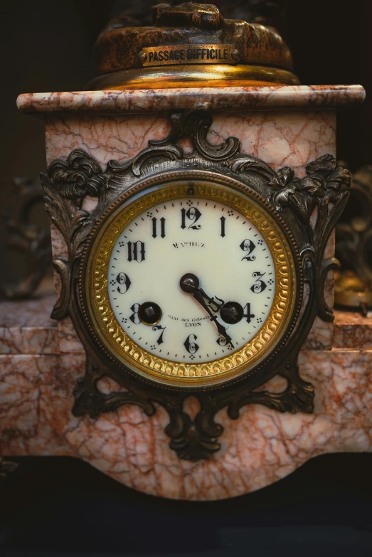 a marble clock on top of a gold pedestal