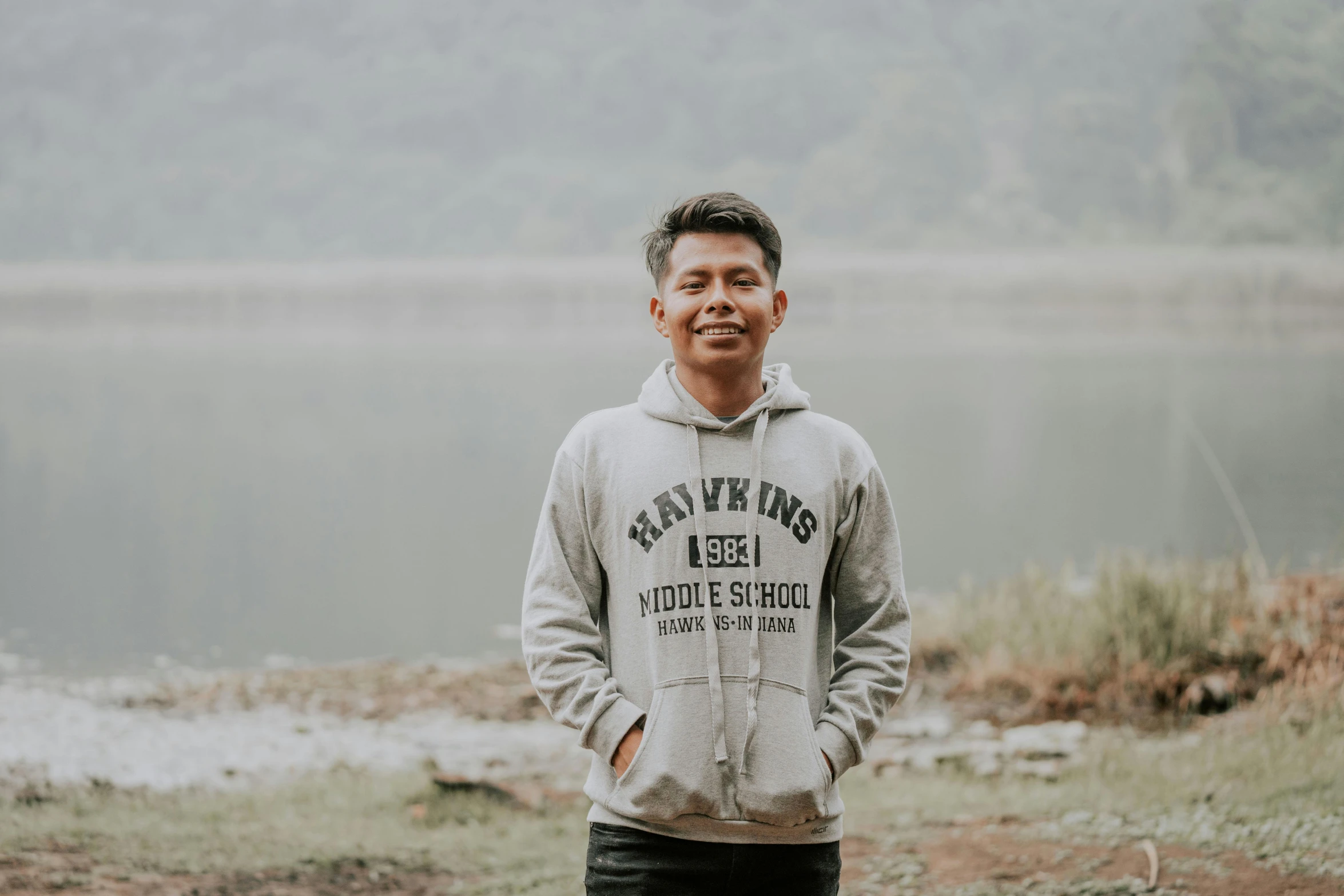 a man standing near a lake in the rain