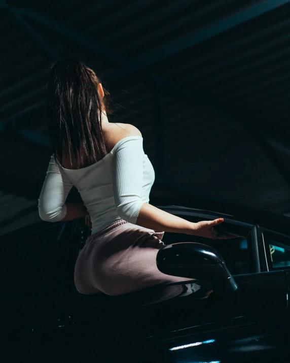 woman getting out of a car in a dark room