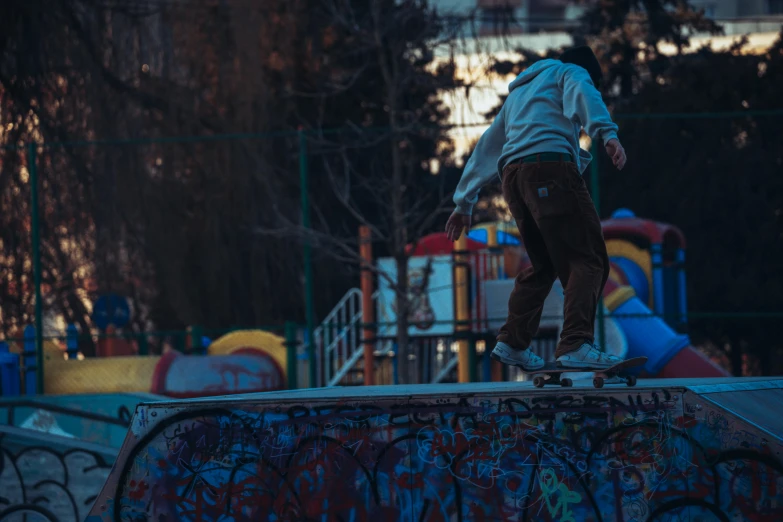 a man riding a skateboard on the top of a ramp