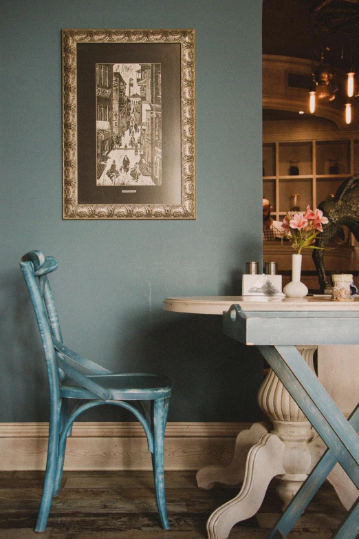 two chairs in front of a table that is painted aqua