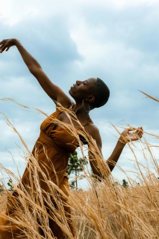 boy reaching high toward the sky in tall grass