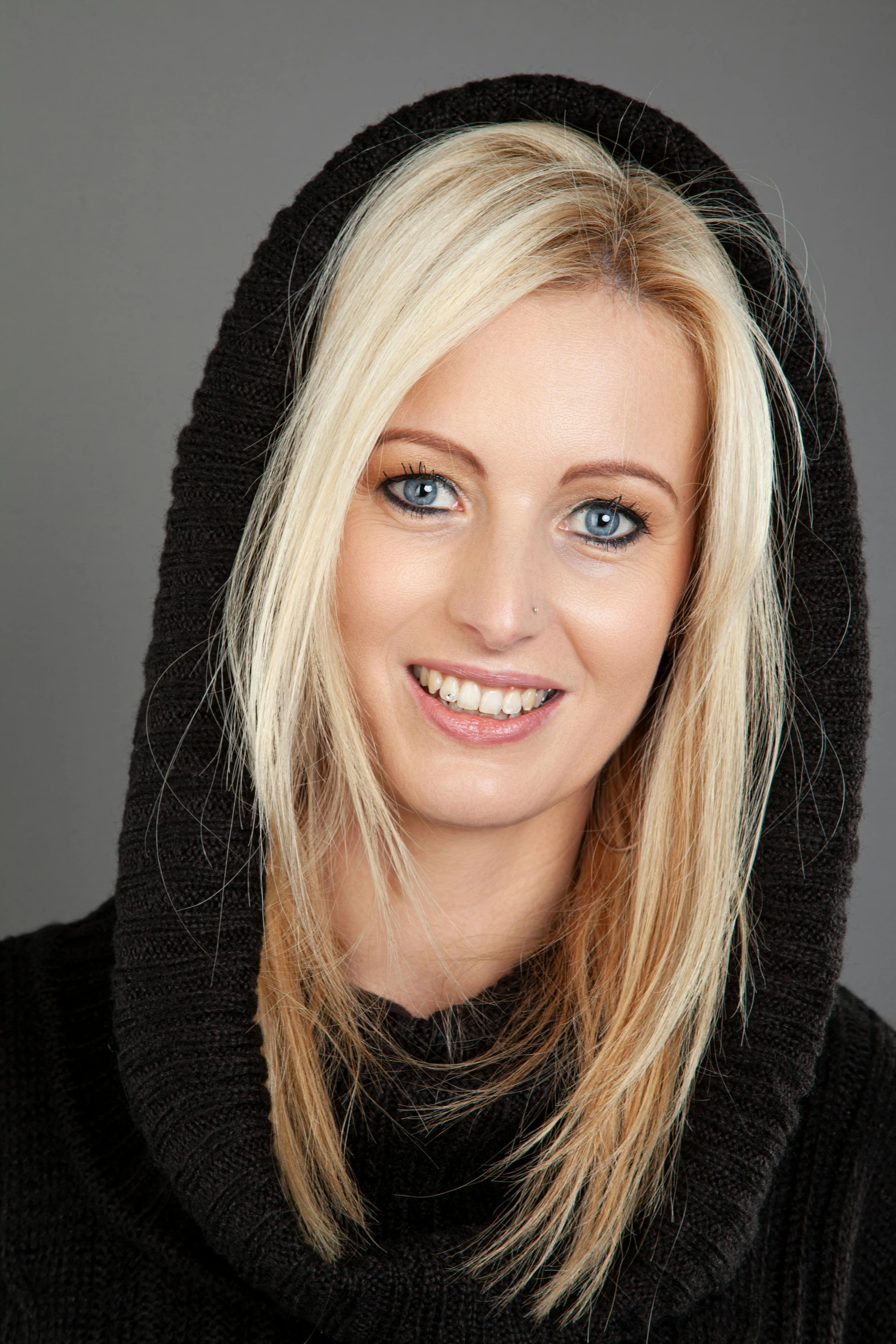 a beautiful blonde woman wearing a hooded coat