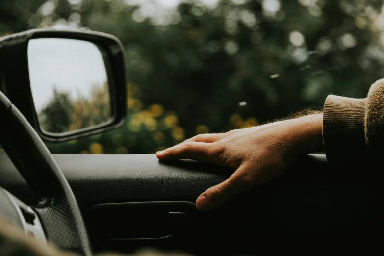 a hand rests on the dashboard of a vehicle