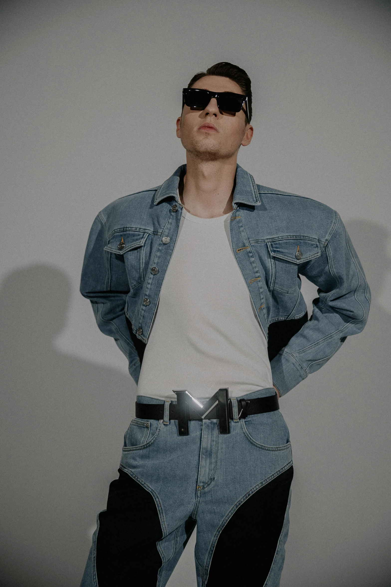 young man wearing jeans and a white t - shirt, and sunglasses