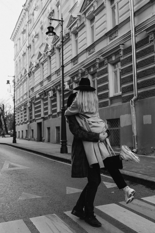 two people walking down the street carrying luggage