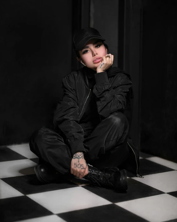 young woman wearing a black hat sitting on the ground