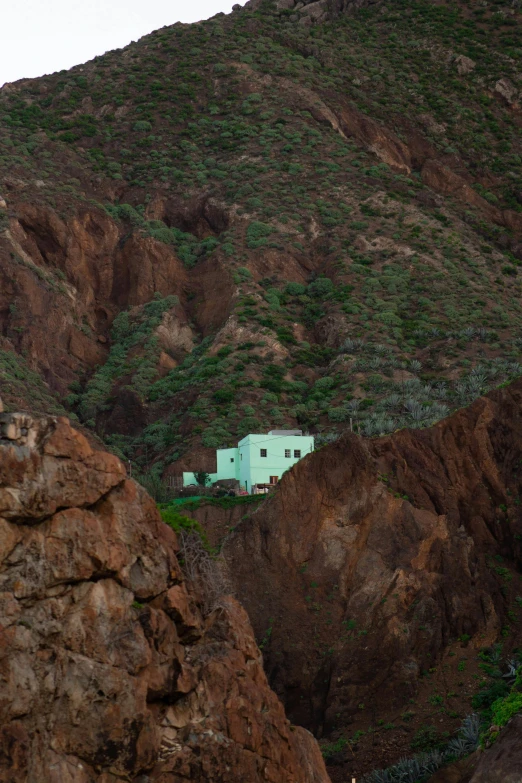 a small white house in the middle of some hills