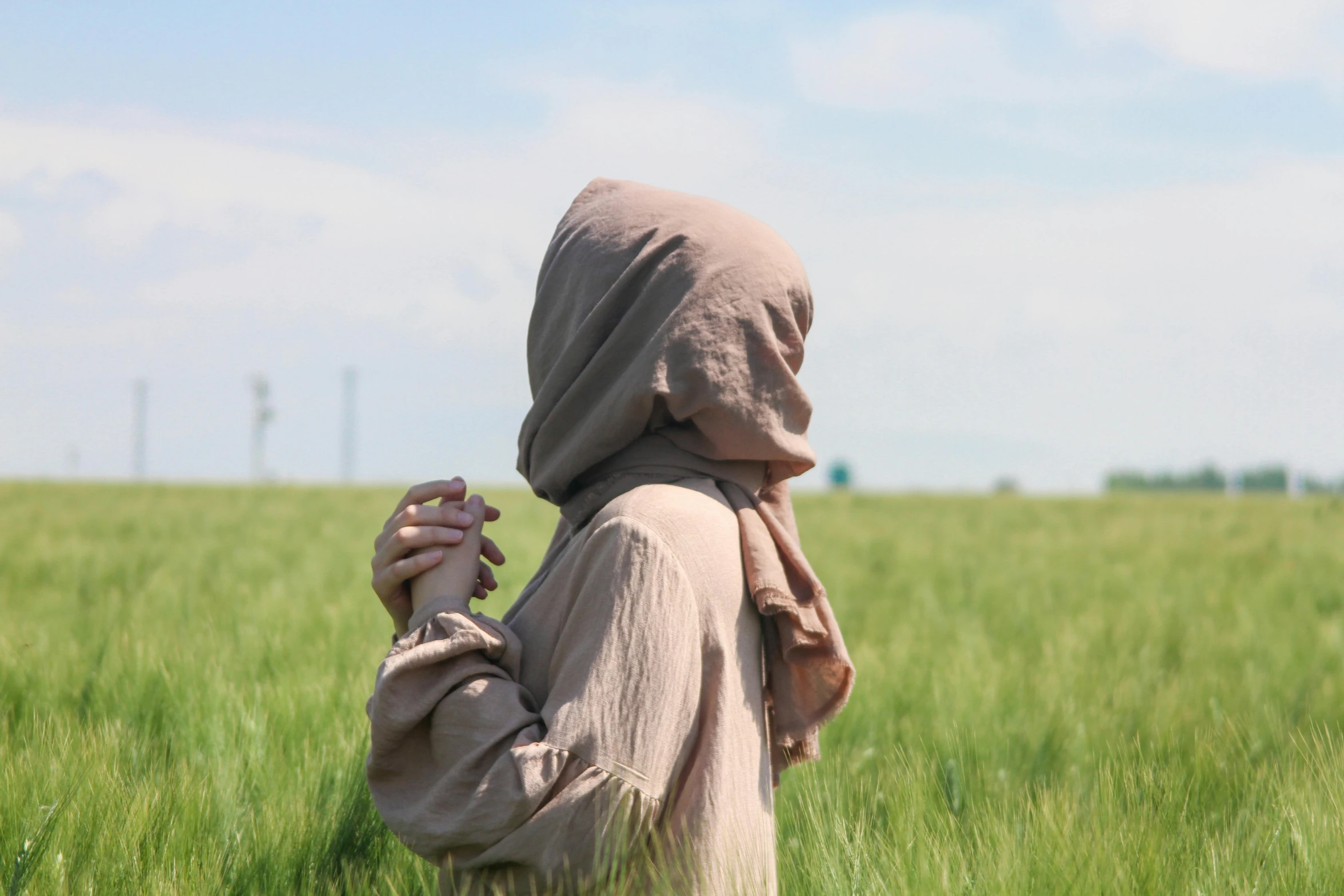 woman with a veil walking in a large green field