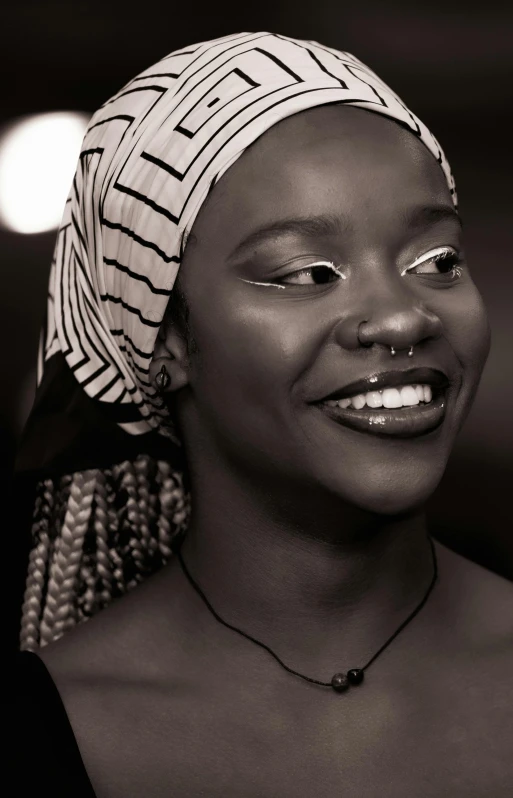 a woman wearing a headscarf smiling for a pograph