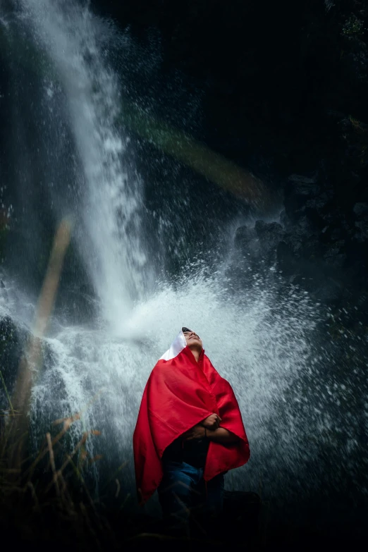 a man is covering his face from a waterfall