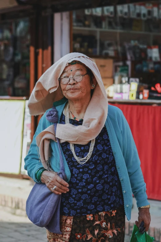 an old lady wearing a hat and holding a green bag