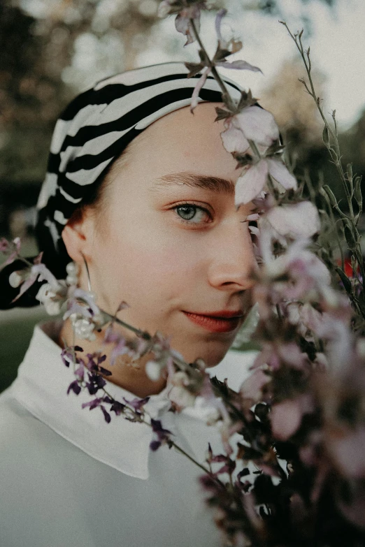 a woman in black and white is holding a flower bush