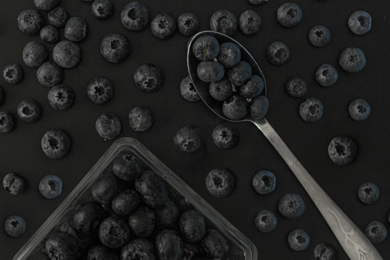 a wooden spoon resting on a pile of ripe berries