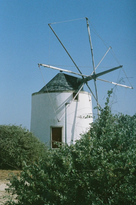 there is a windmill in the trees on a sunny day