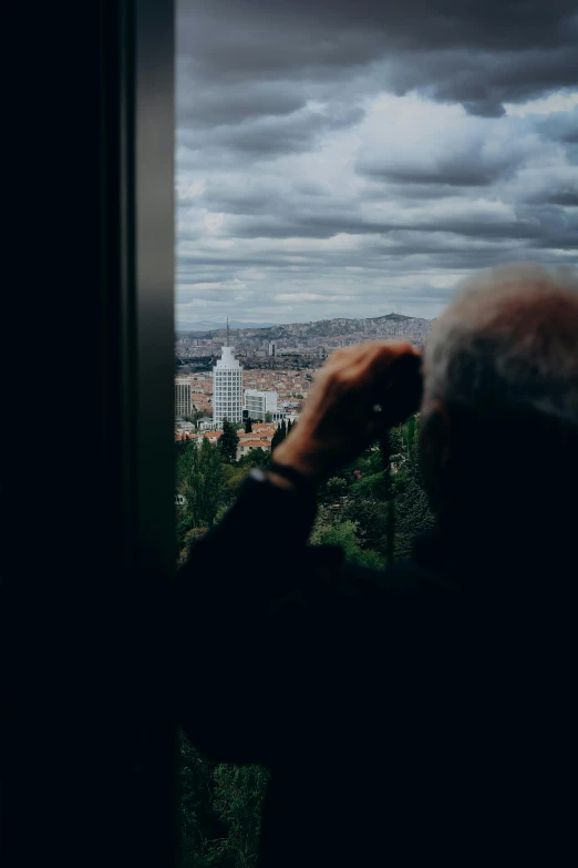 a man in a black jacket looking out over a city