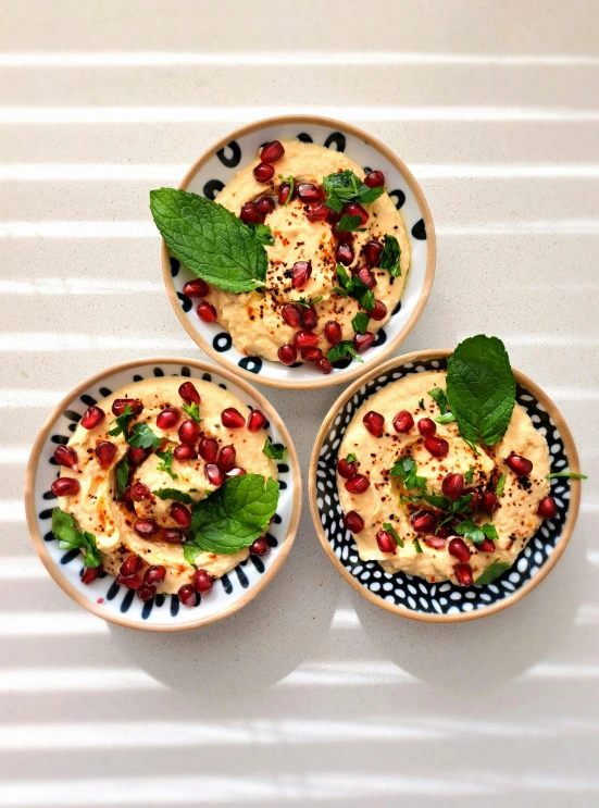 three white bowls topped with different foods