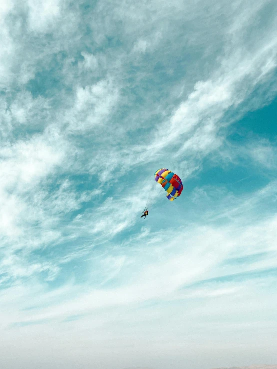 two people are flying kites in the sky over the ocean