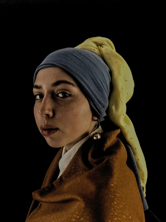 a woman with a yellow turban and a blue nose ring