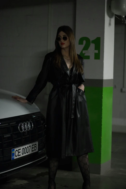 an attractive woman posing by a parked car