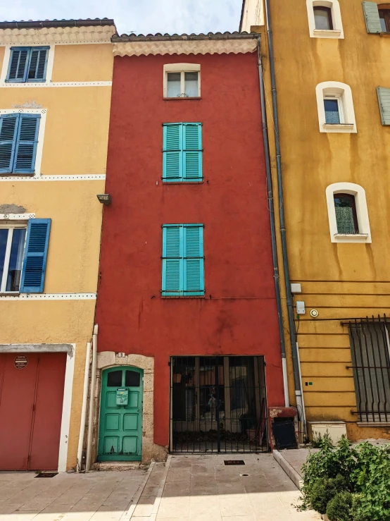 two tall buildings with blue windows and shutters