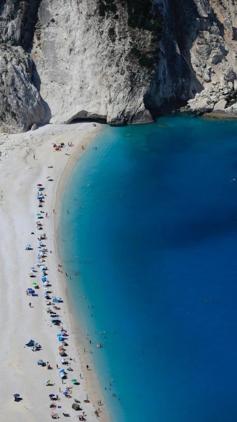 a beach has many people walking along it