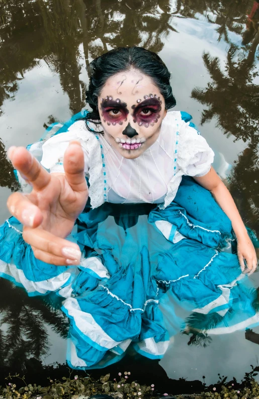 a woman wearing makeup and eyes painted blue is floating on water