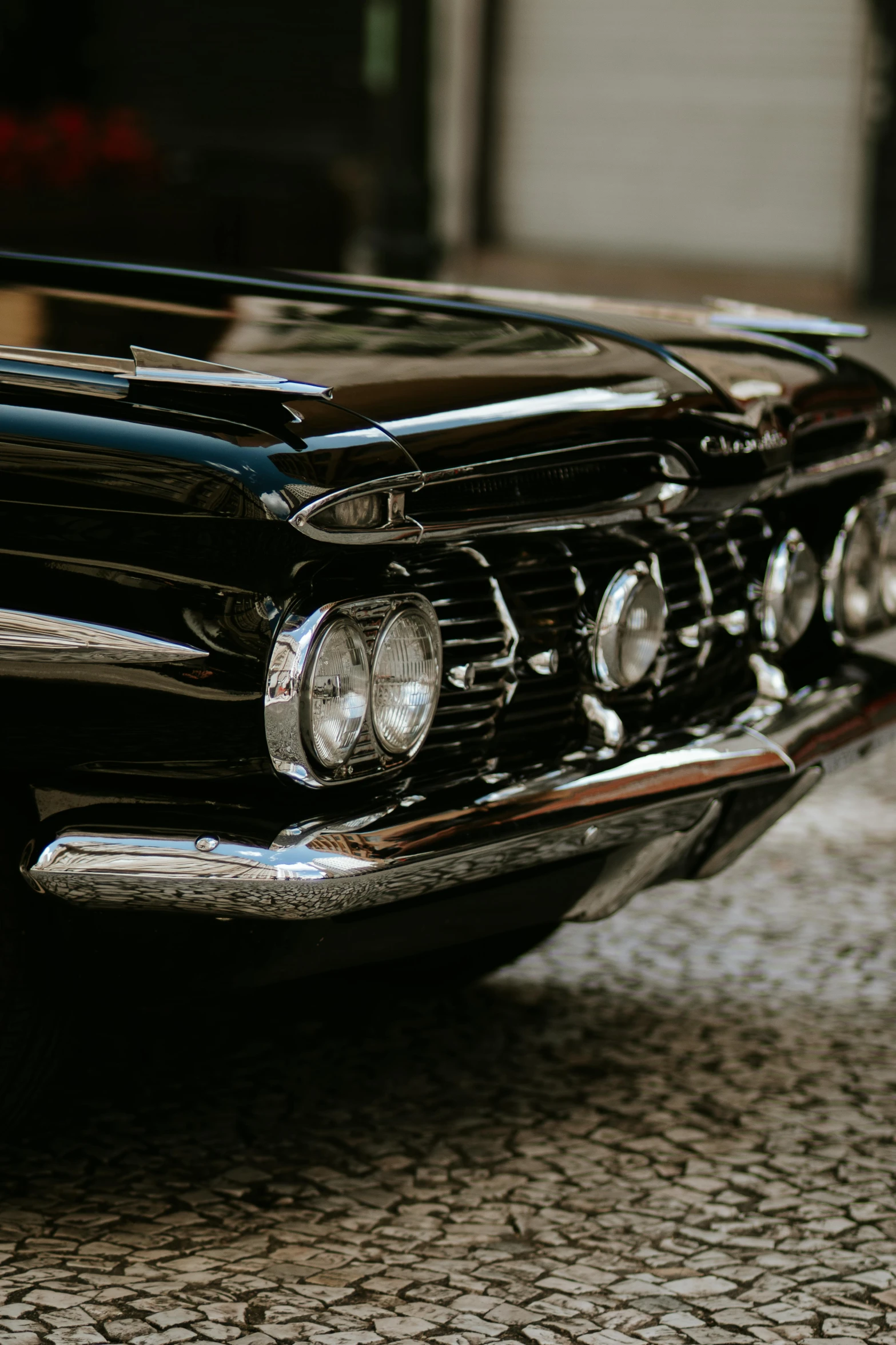 an old black car is sitting on a road