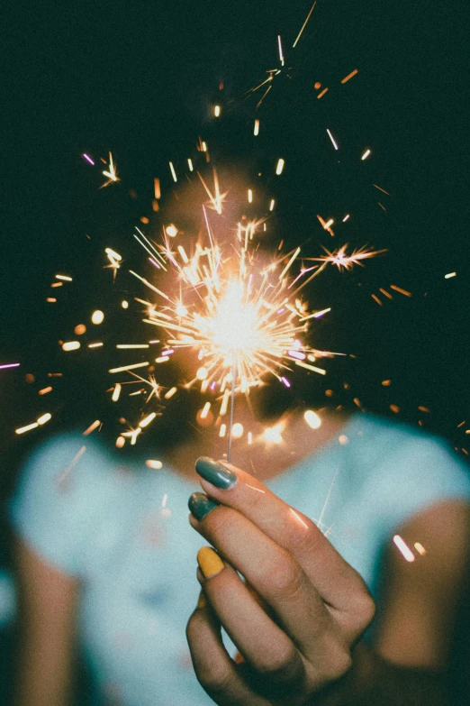 a woman's hand holding a sparkler