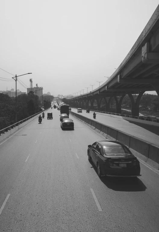 several cars travelling on a highway in the rain